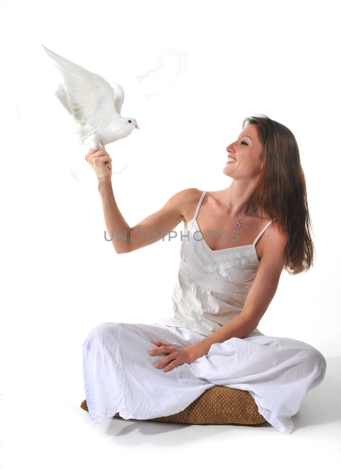 young smiling woman and her white dove in a studio