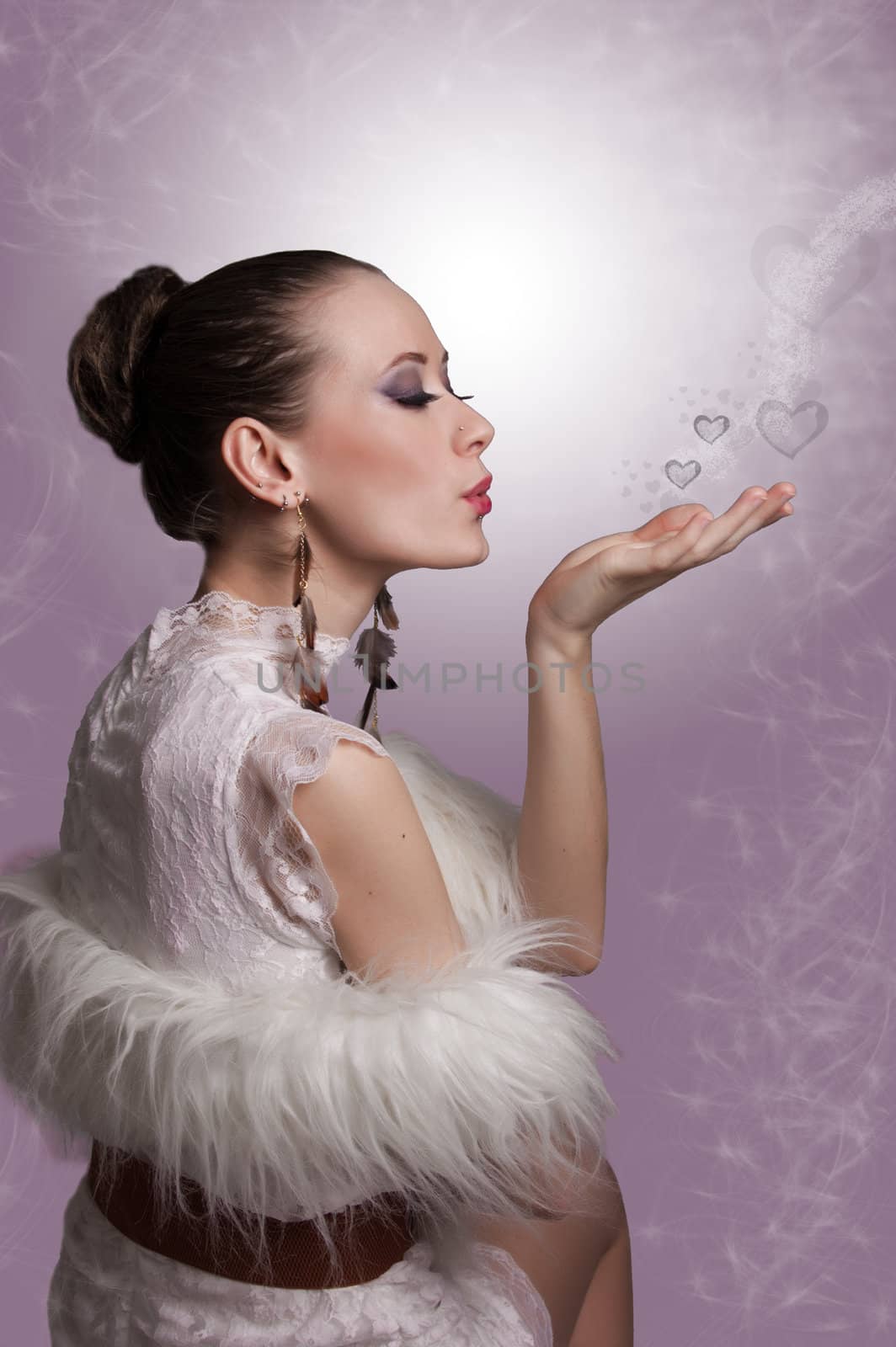 Elegant woman sending kiss with hearts over pink background