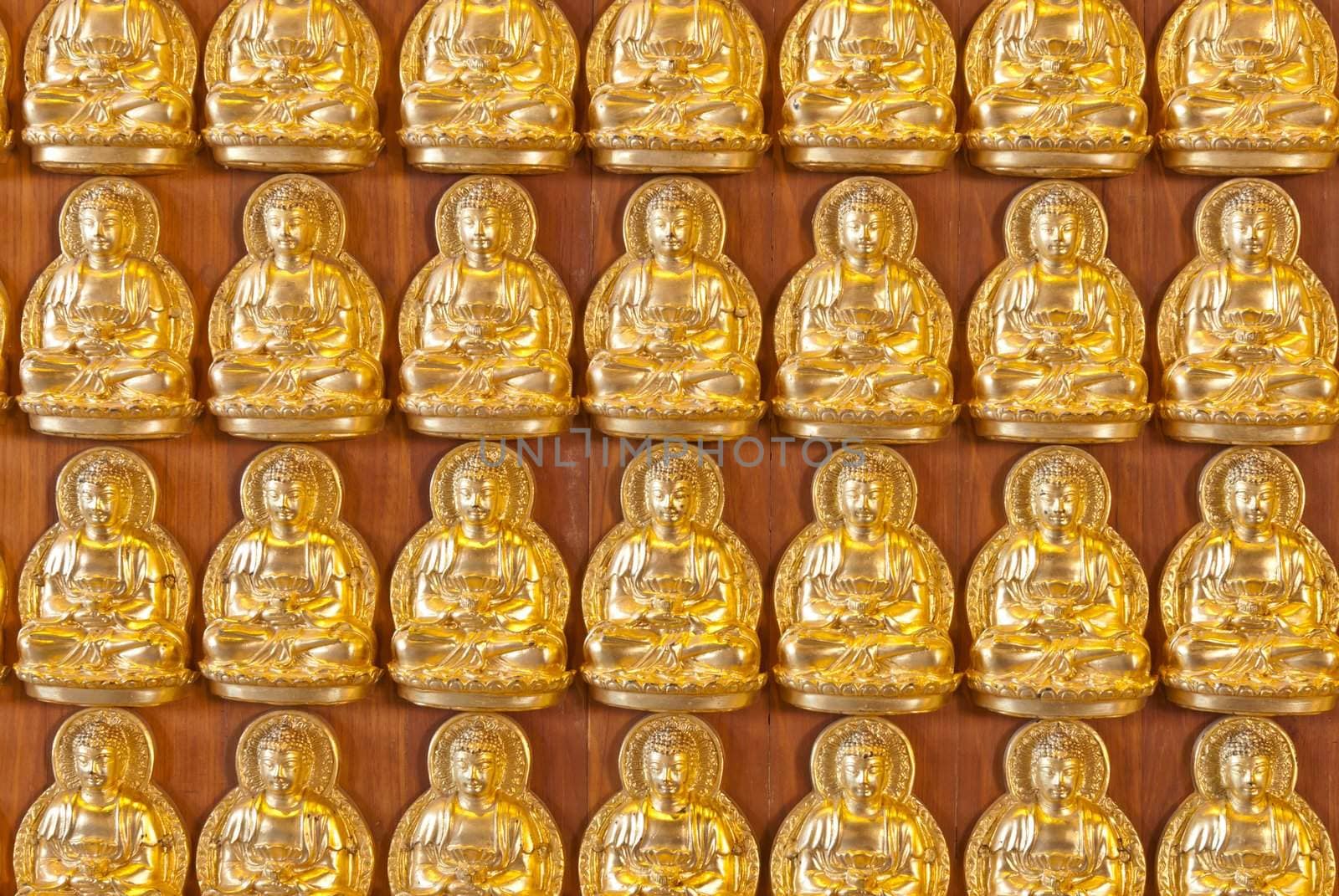 Hundreds of golden Buddha statues background at chinese temple