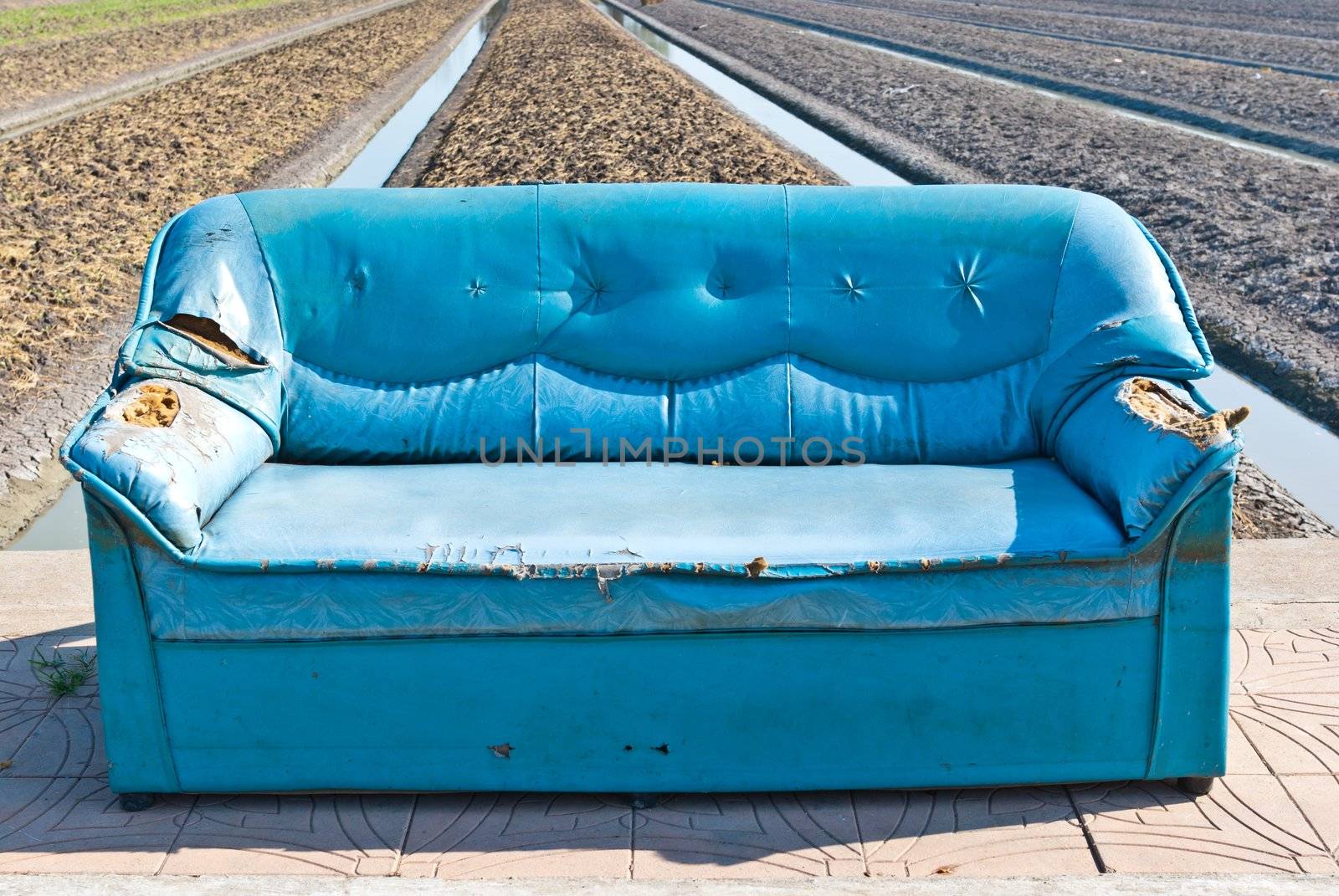 Very old vintage blue sofa on the street, can be use for background and other vintage related concepts.