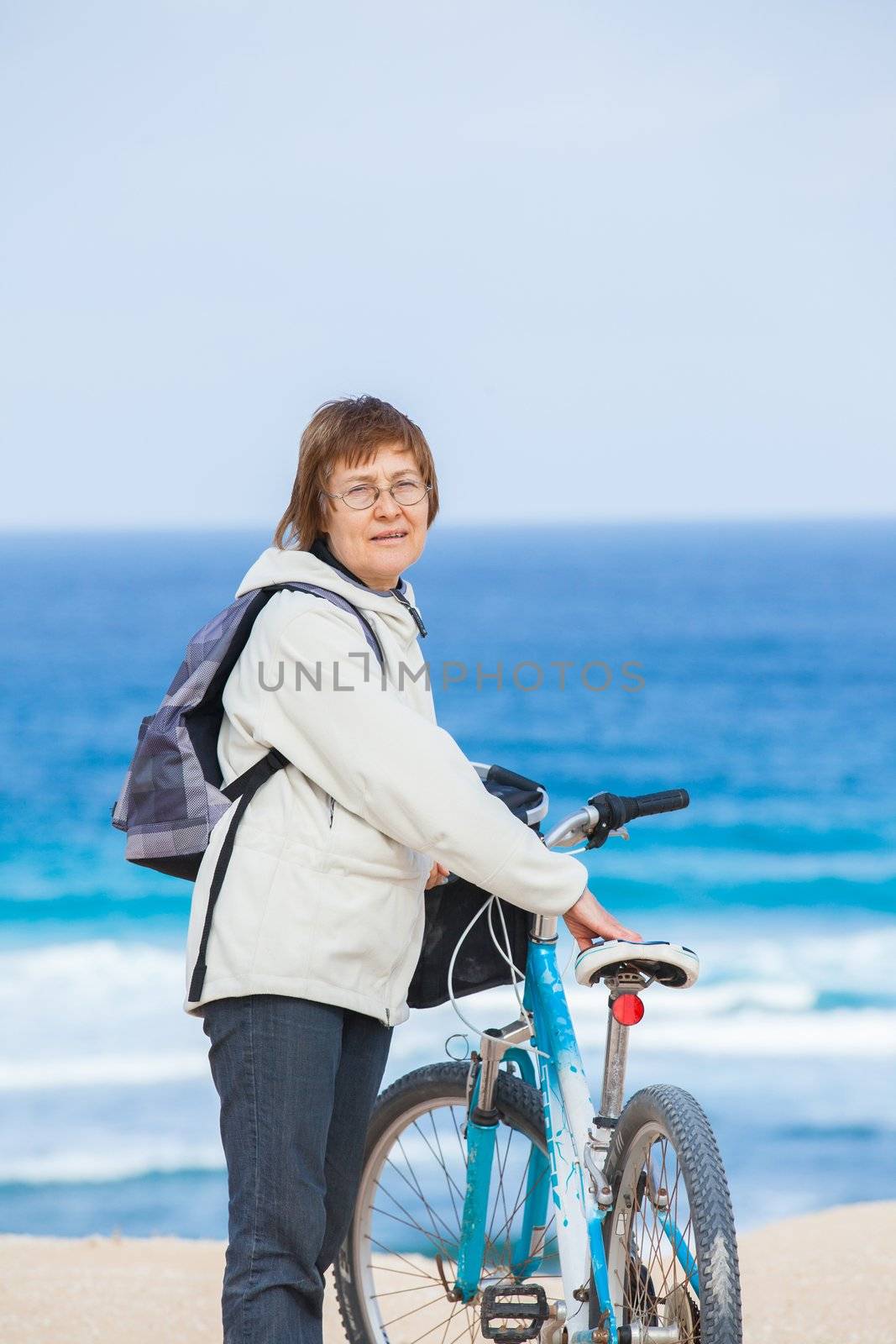 A nice senior lady riding a bike on the beach. Lanzarote. Canaries