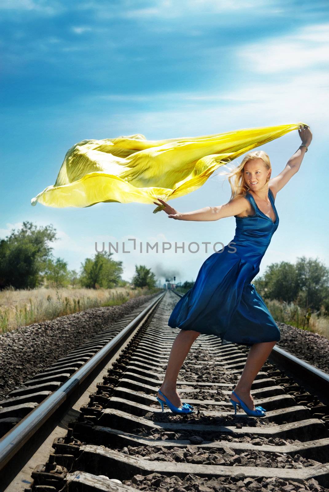 Model with yellow fabric on the railway and train on the background