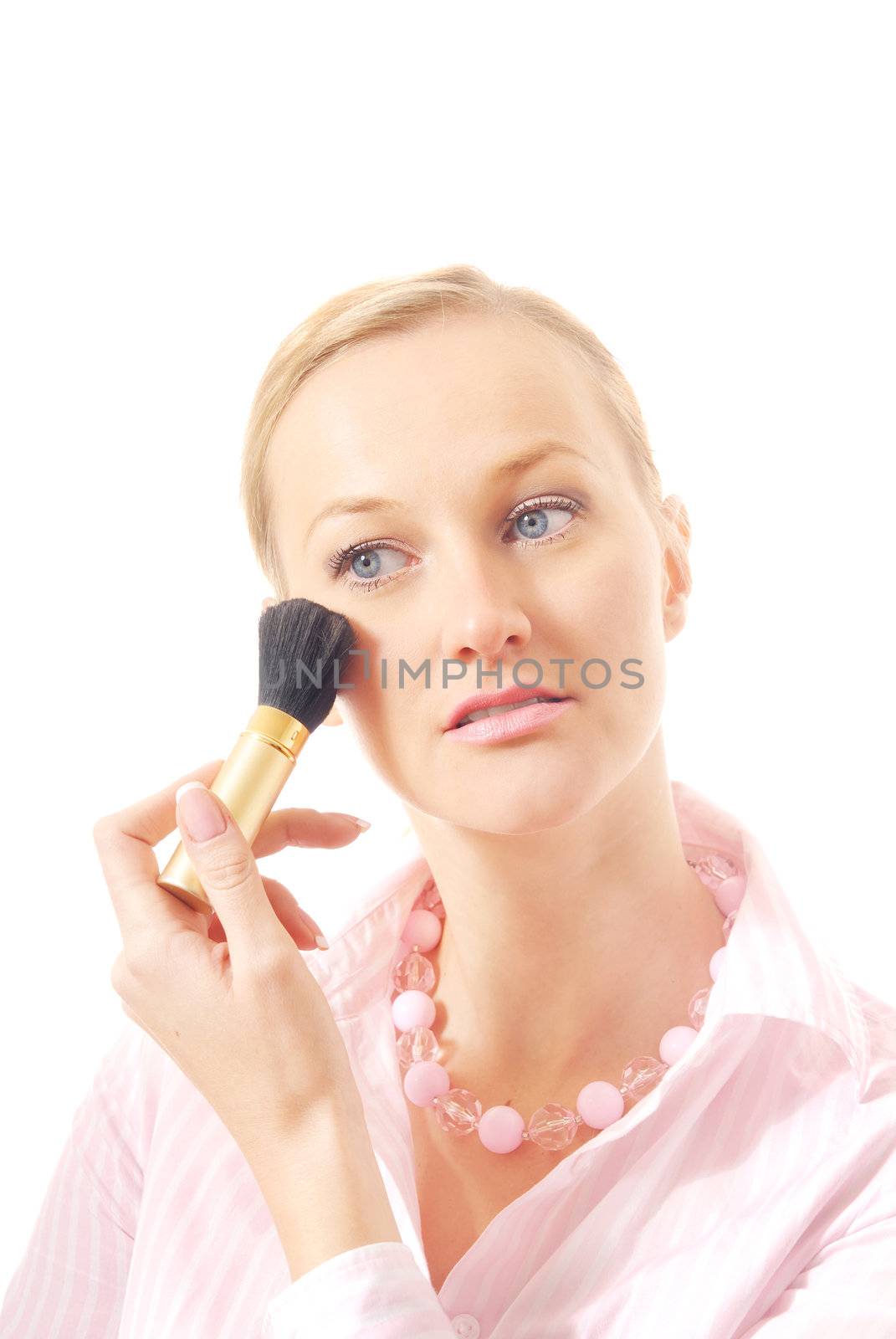 Caucasian woman with makeup brush applying face powder