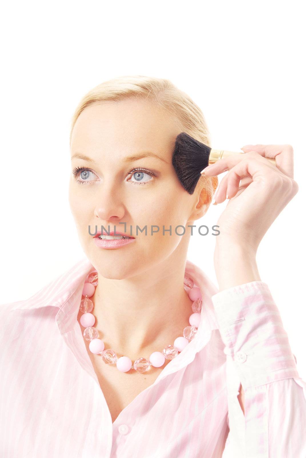 Studio photo of the blonde with beauty brush making a makeup