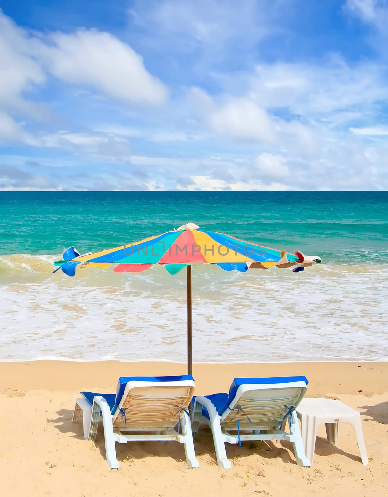 Couple chair and multi-color umbrella on the beach with perfectly sky