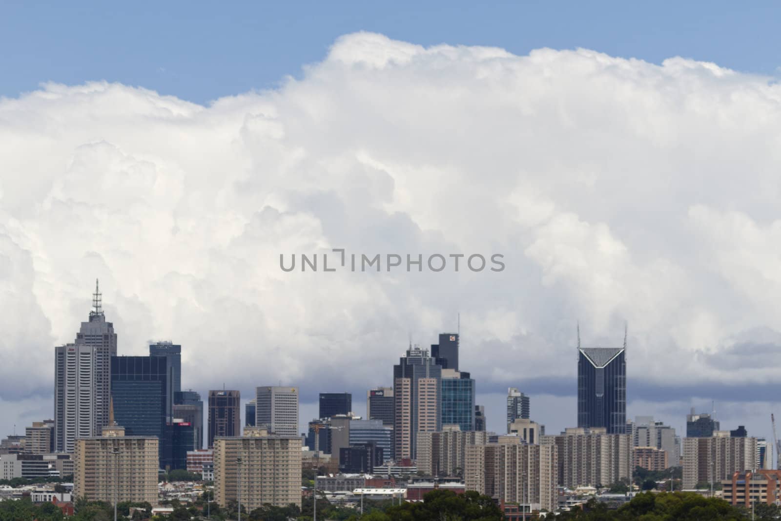 Cityscape of Melbourne, Australia; skyline of city with billowing white clouds and blue skys above and beyond. Location is province of Victoria, Melbourne, Australia;