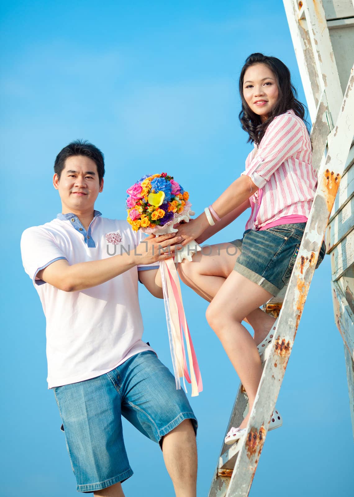 couples holding beautiful flowers bouquet together on the beach