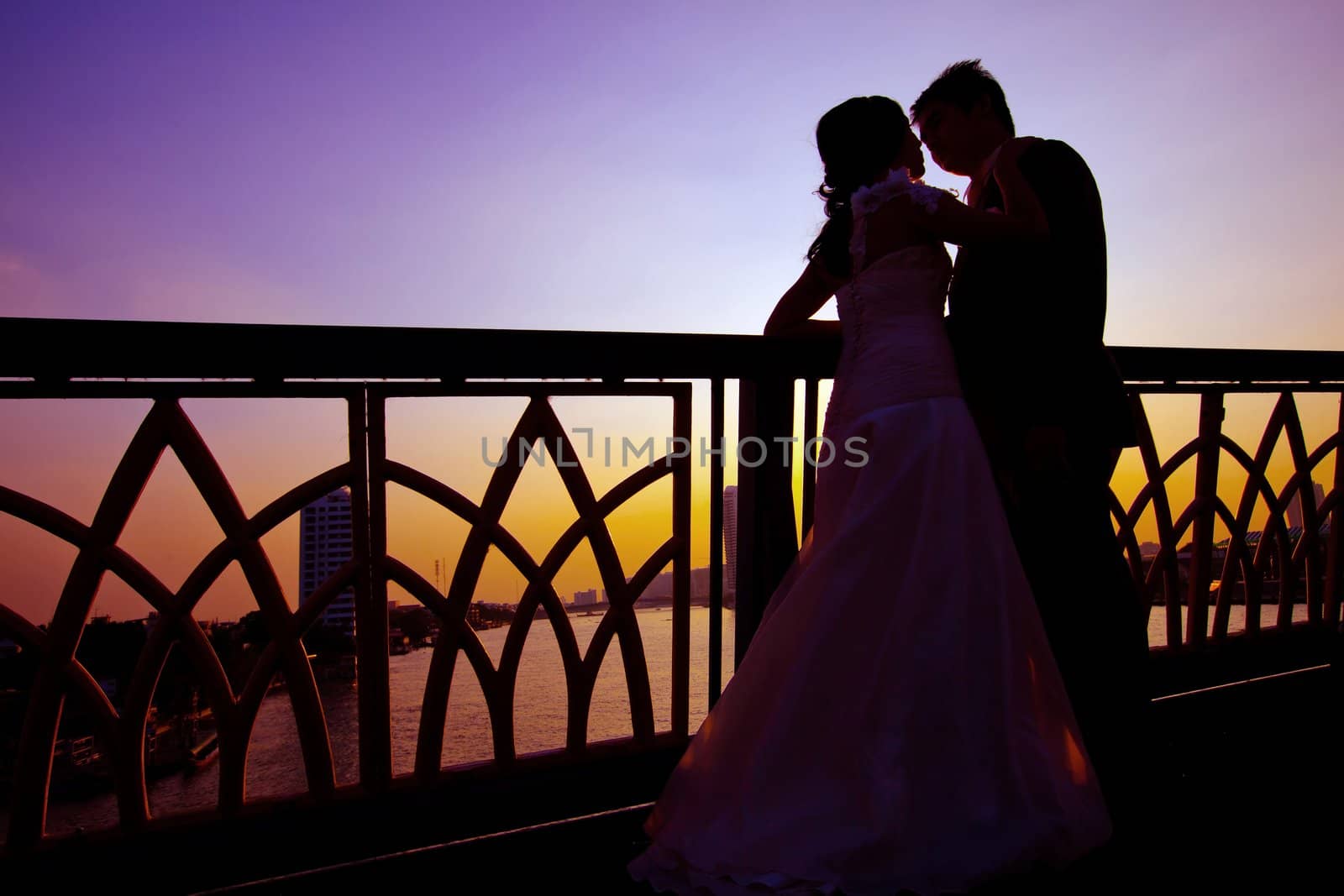 shilhouette of romantic and happiness couples on the bridge over the river