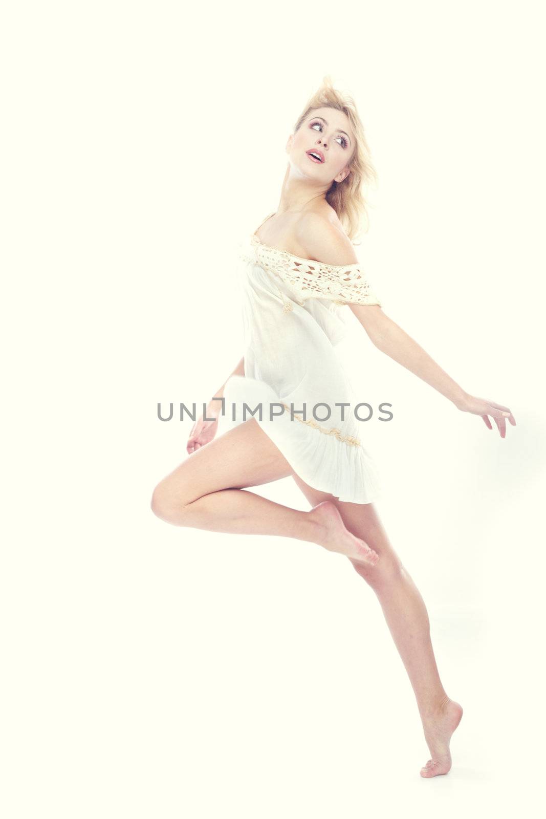 Blond lady dancing on a studio background