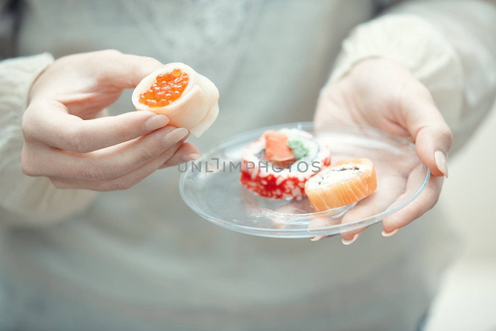 Human hands holding place with sushi