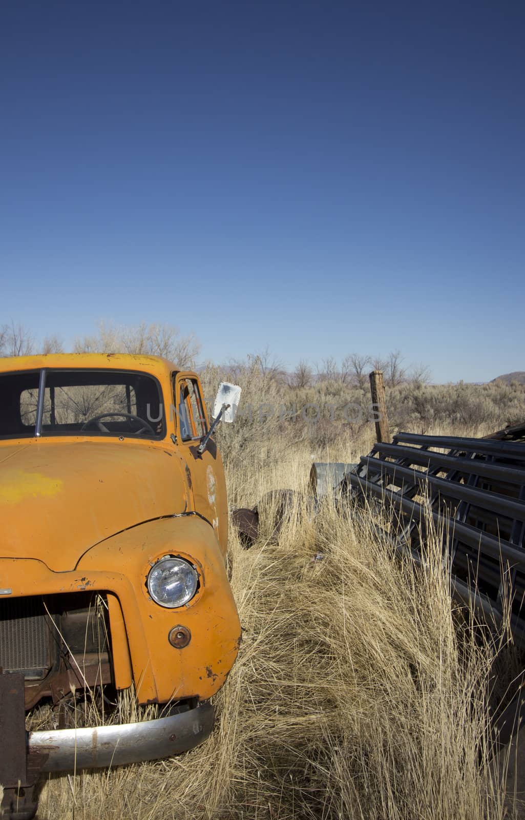 an old abandoned orange truck in the farm lands.