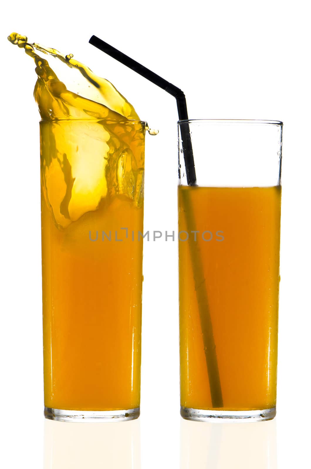 Two cups of orange juice over white reflective background.