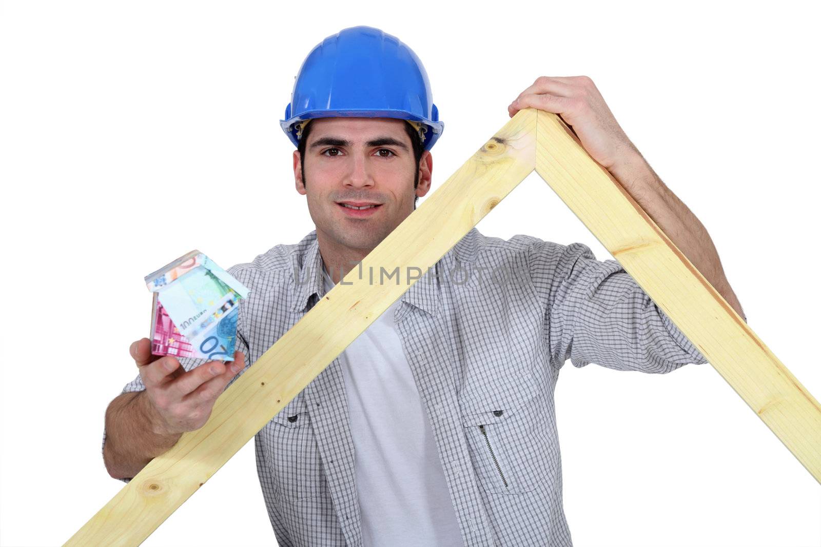 Carpenter stood with wooden truss and money