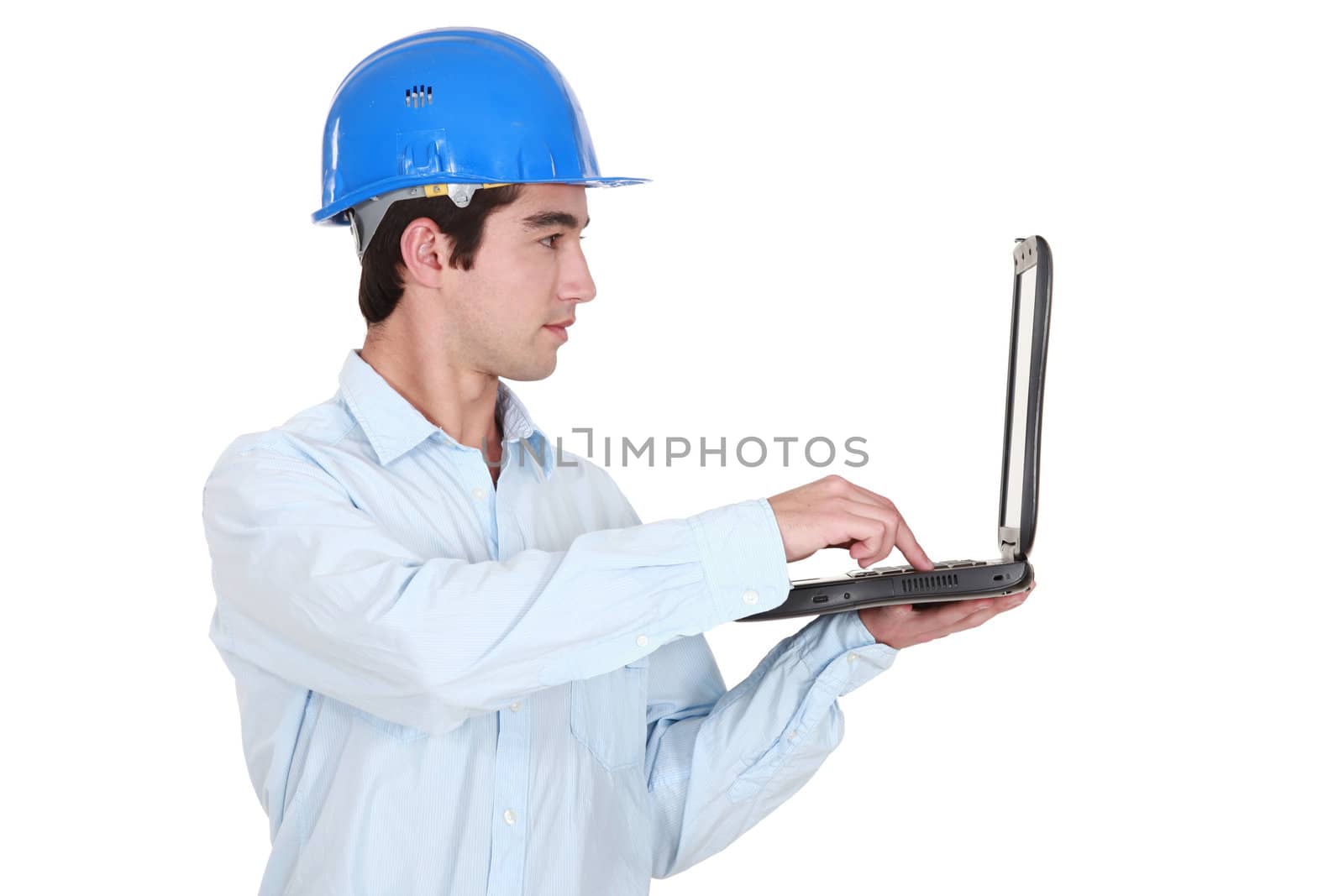 Man in a hardhat with a laptop by phovoir