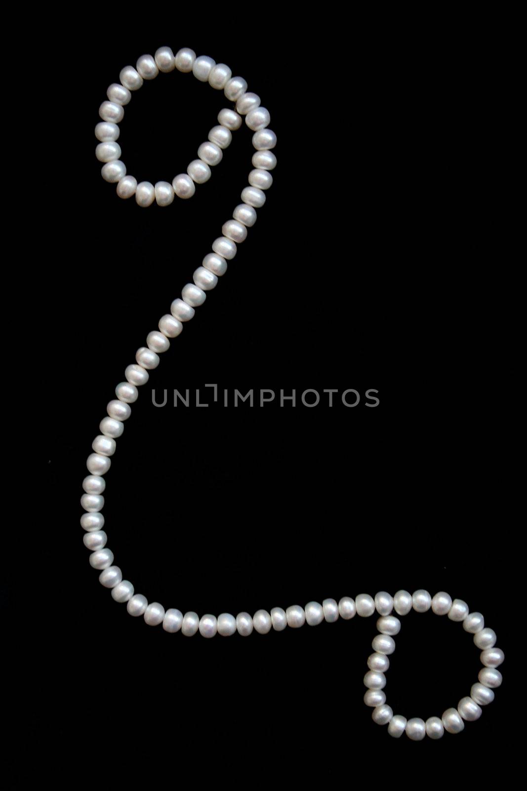 White pearls on the black velvet background 