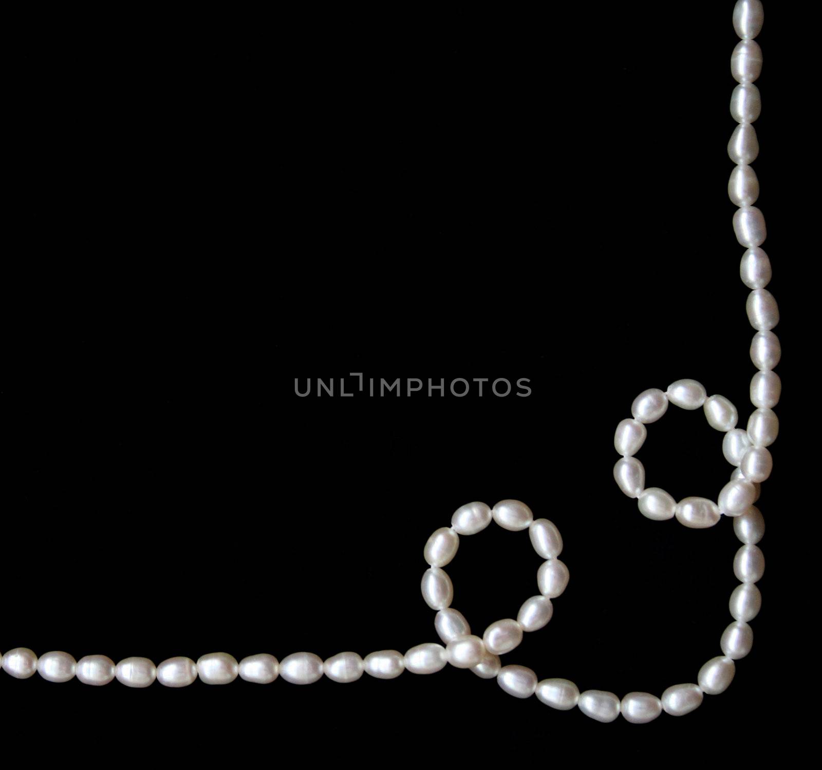 White pearls on the black velvet background 