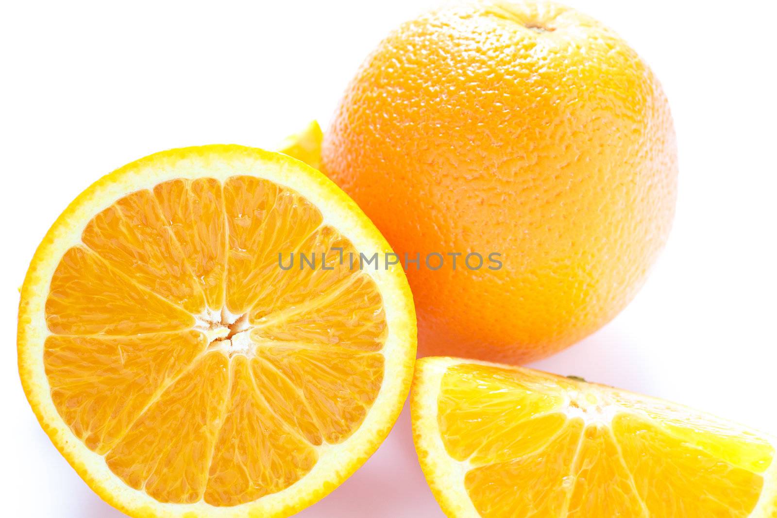 whole and cut oranges on a white counter