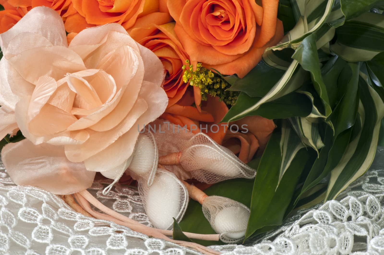 weeding Favors and orange roses on white lace