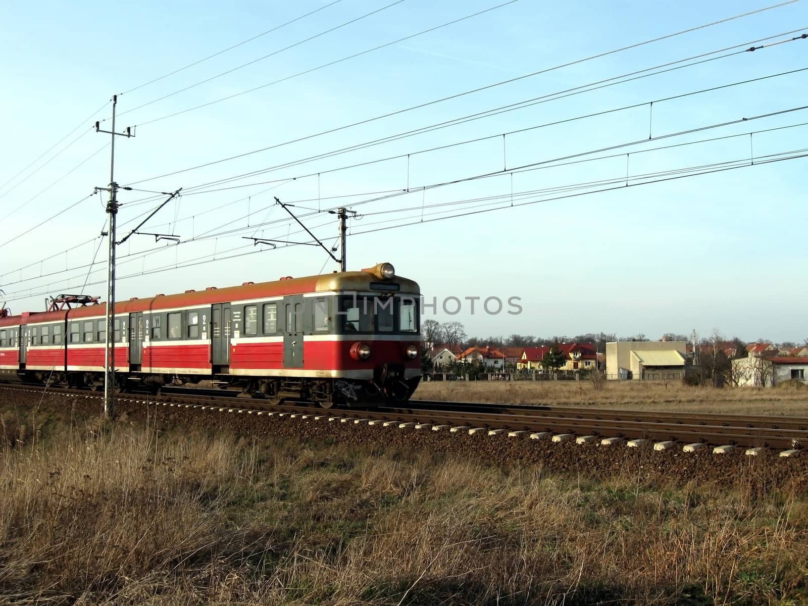 Small train coming back to Wroclaw city in Poland. Passing village and open fields.