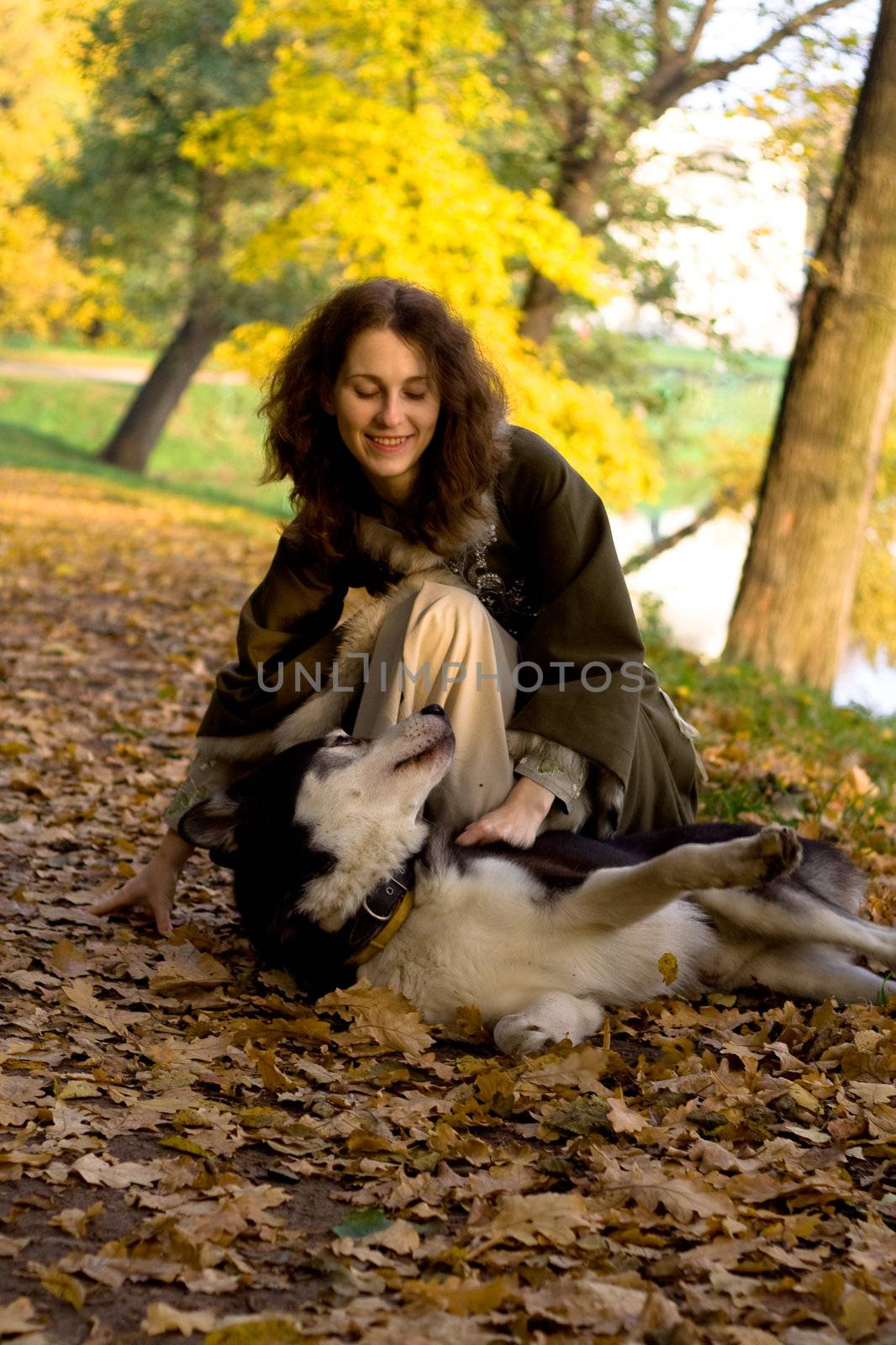 Lady in medieval dress and dog in the forest
