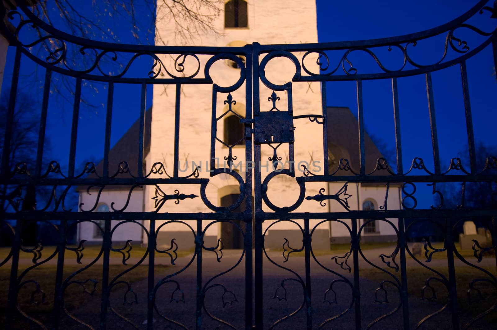 A old iron gate at a entrance to a church and graveyard