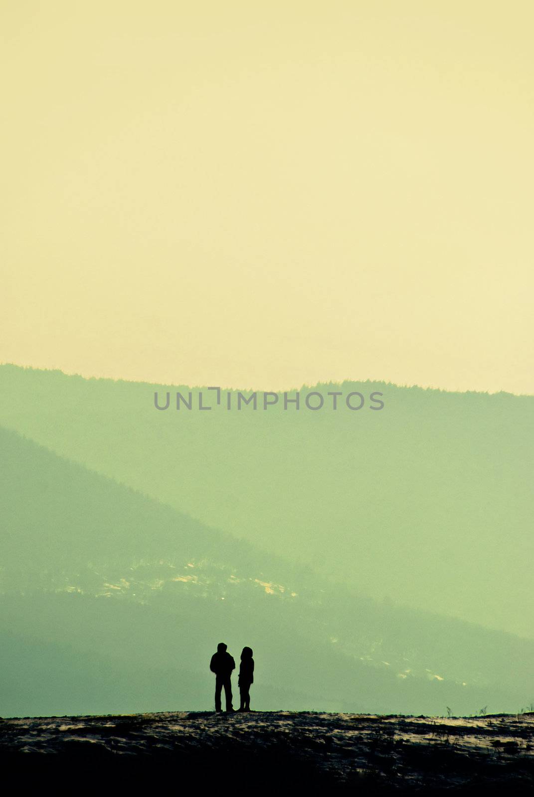 solitude, silhouettes of a man and a woman standing on the hill and talking