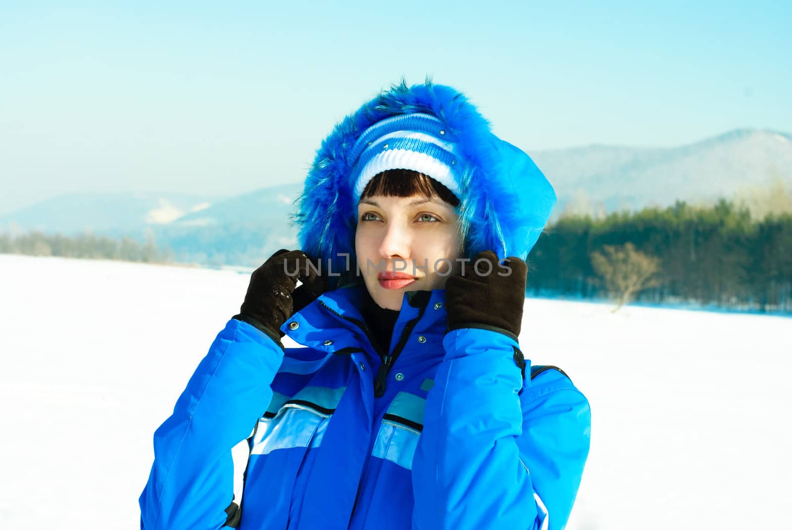 beautiful young woman wearing warm clothes enjoying the sunny winter day