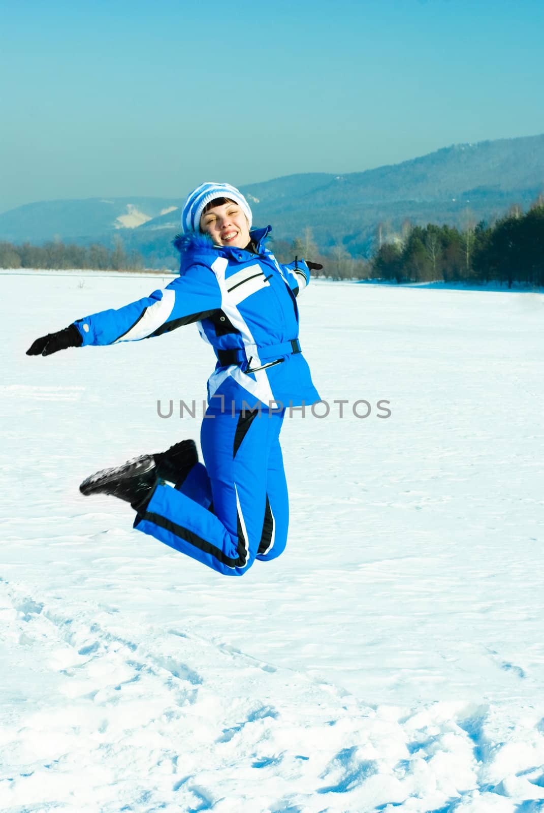 happy young woman jumping and having fun outdoor in wintertime