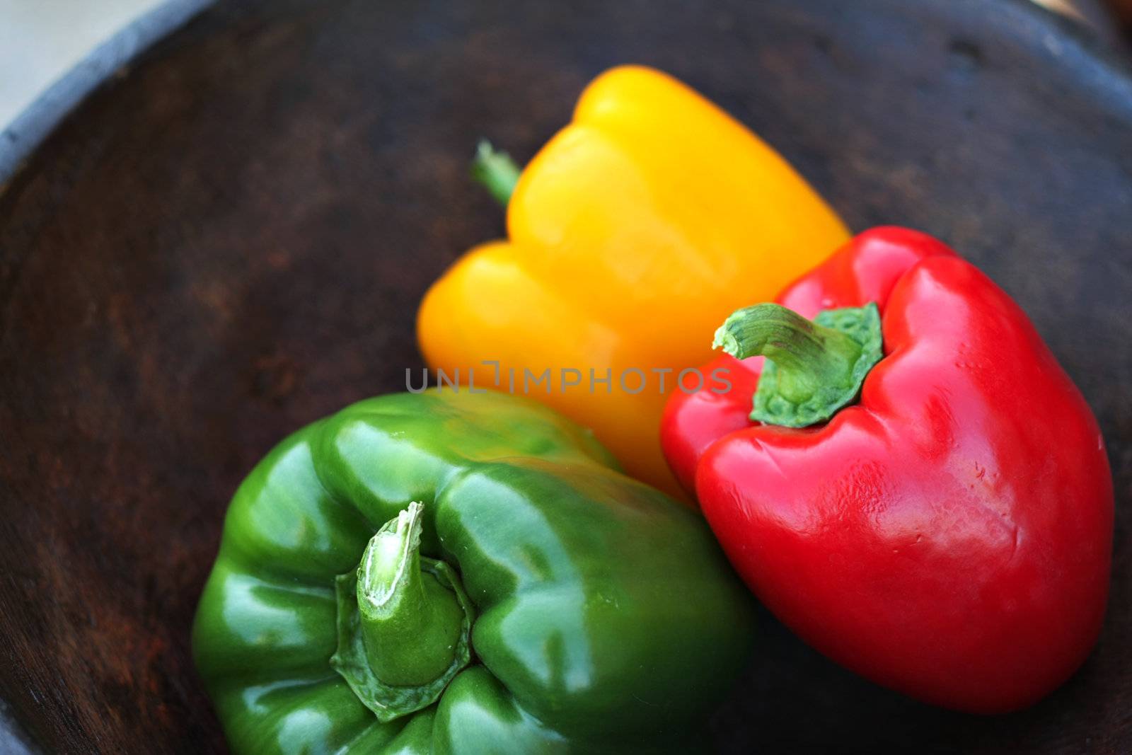 Colorful peppers in a hand carved wooden bowl