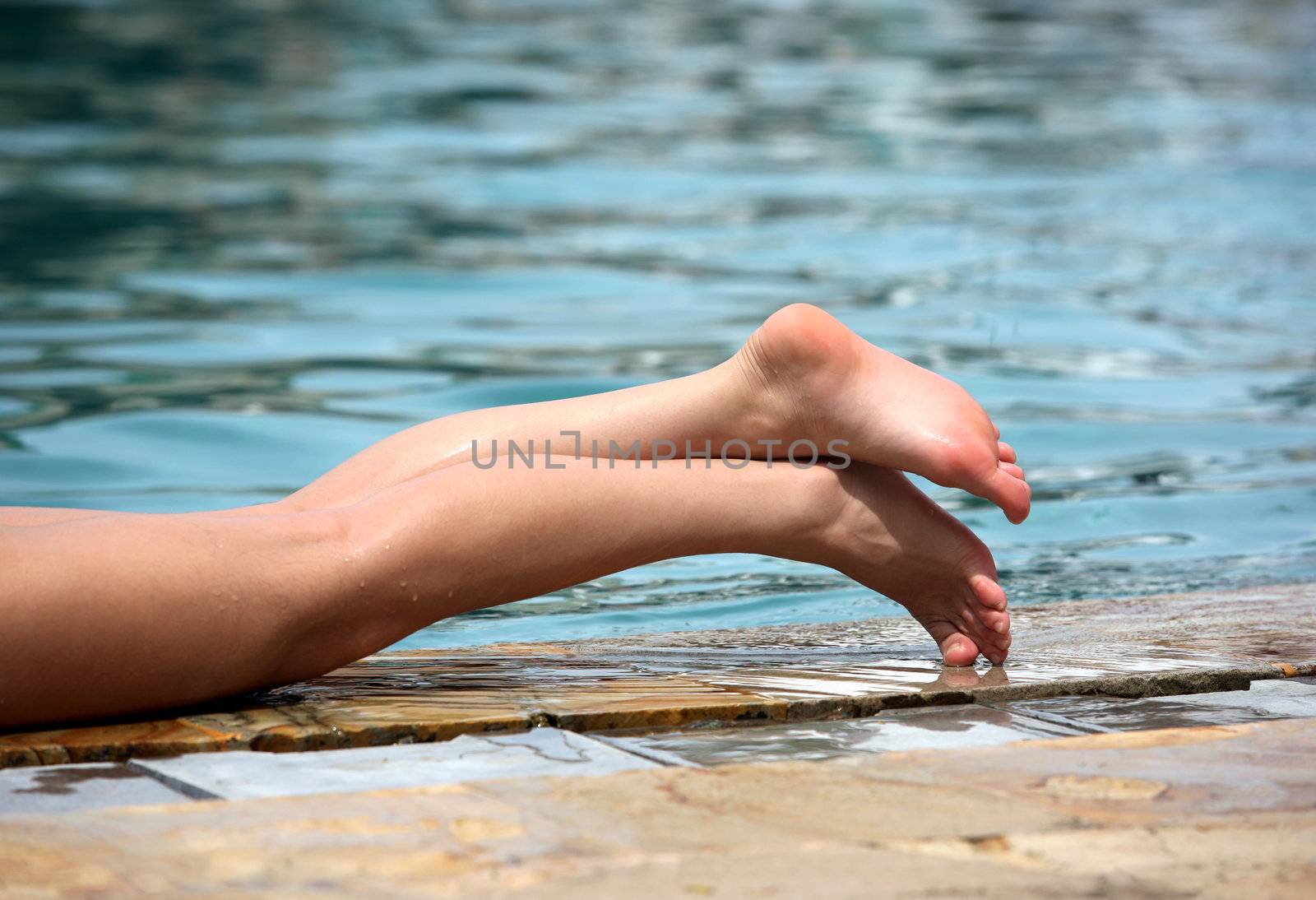 Beautiful legs enjoying summer in the pool