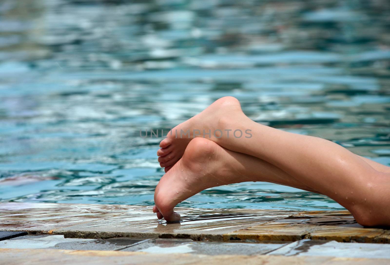 Beautiful legs enjoying summer in the pool