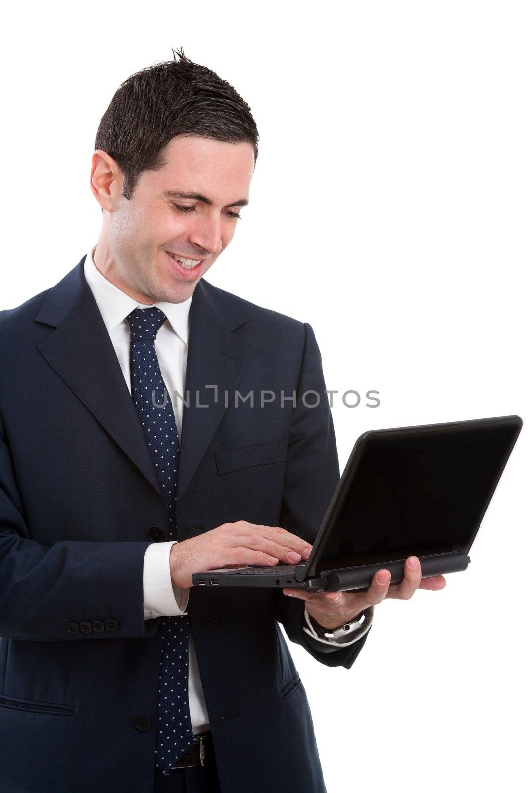 Handsome young business man in blue suit working on laptop. Isolated on white.