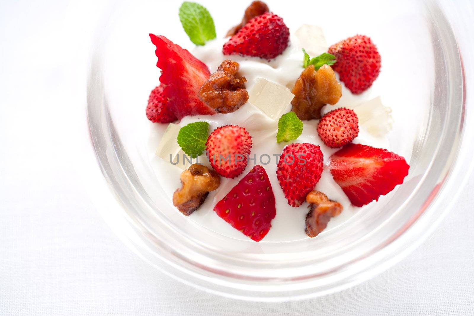 Horizontal Close up of yogurt dessert with strawberries and caramelized nut dressing and copy space