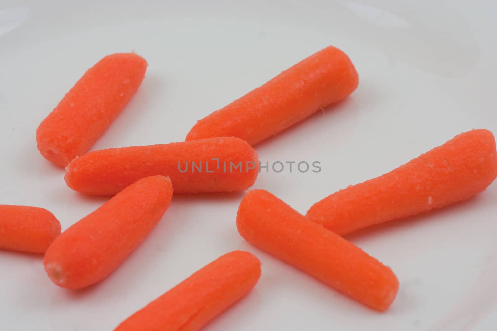 Baby carrotts laid out  on a white background