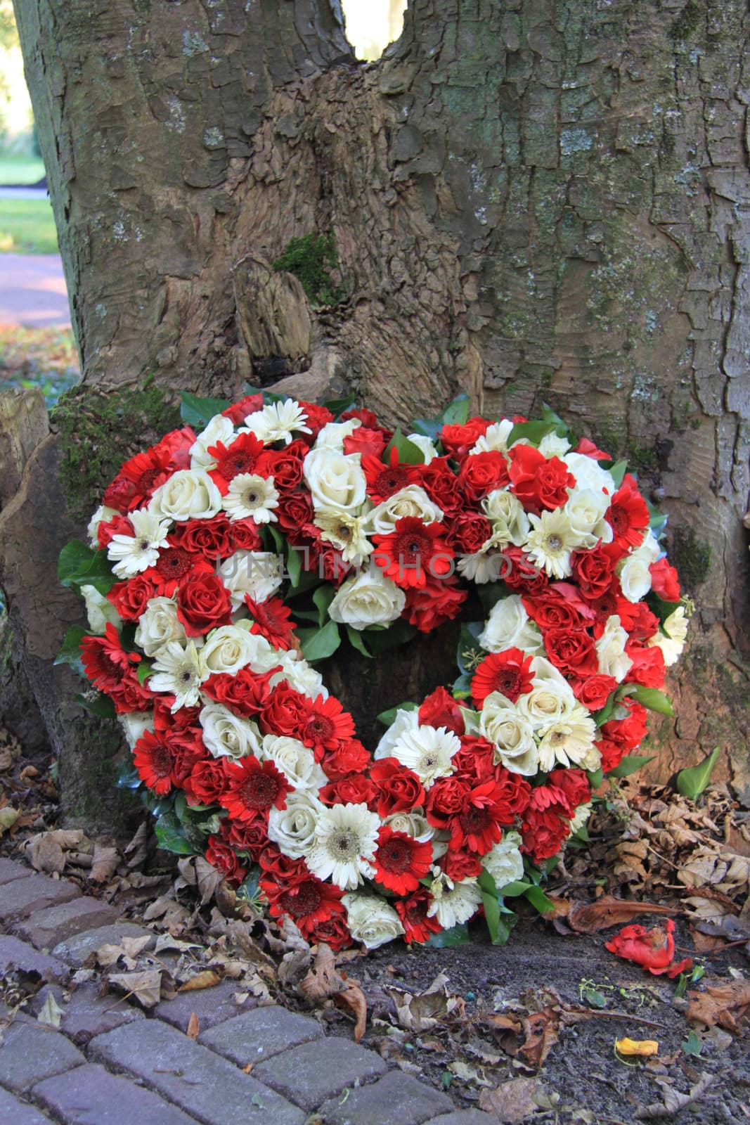 Heart shaped sympathy flower arrangement with red and white flowers