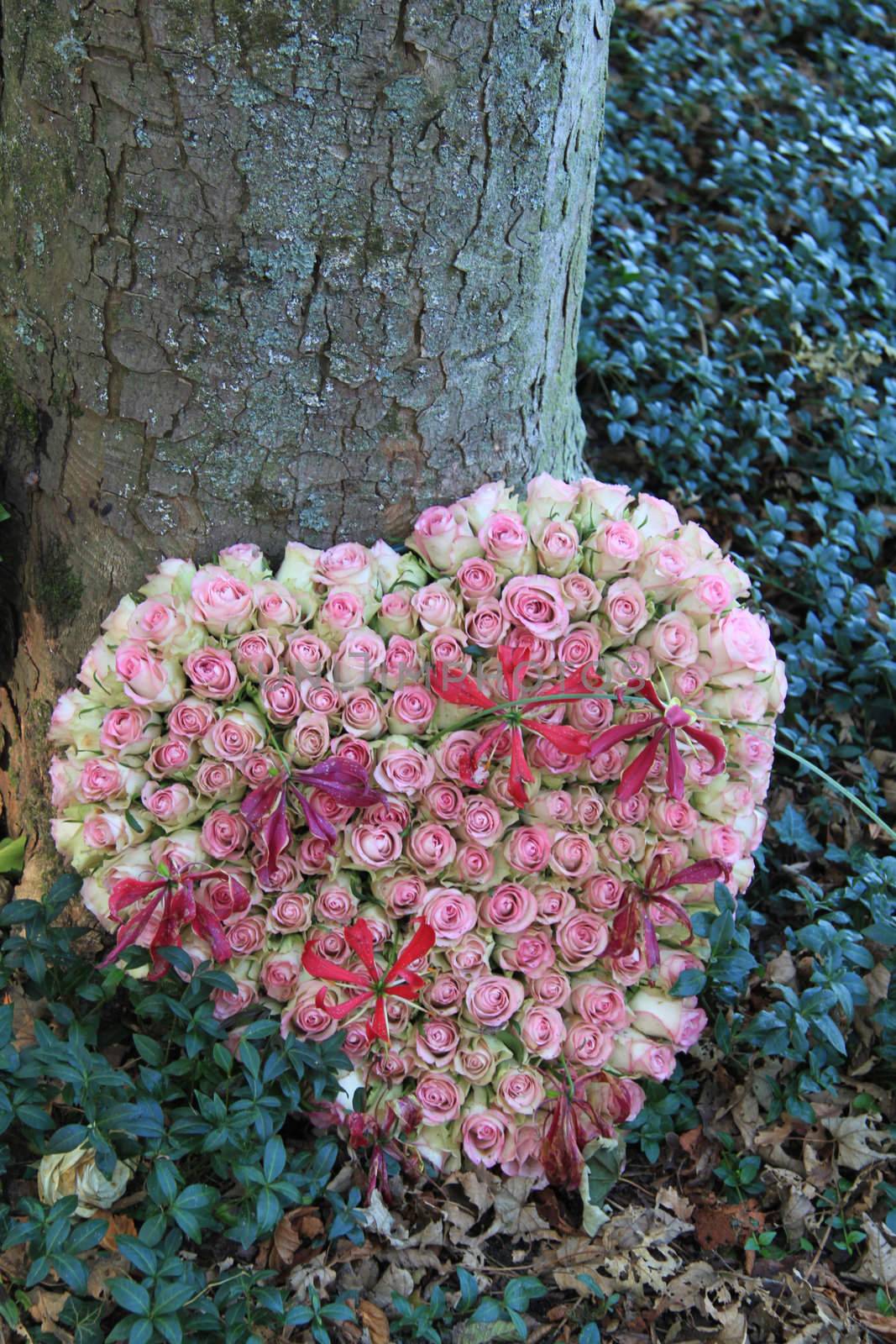 Heart shaped sympathy flower arrangement with pink roses