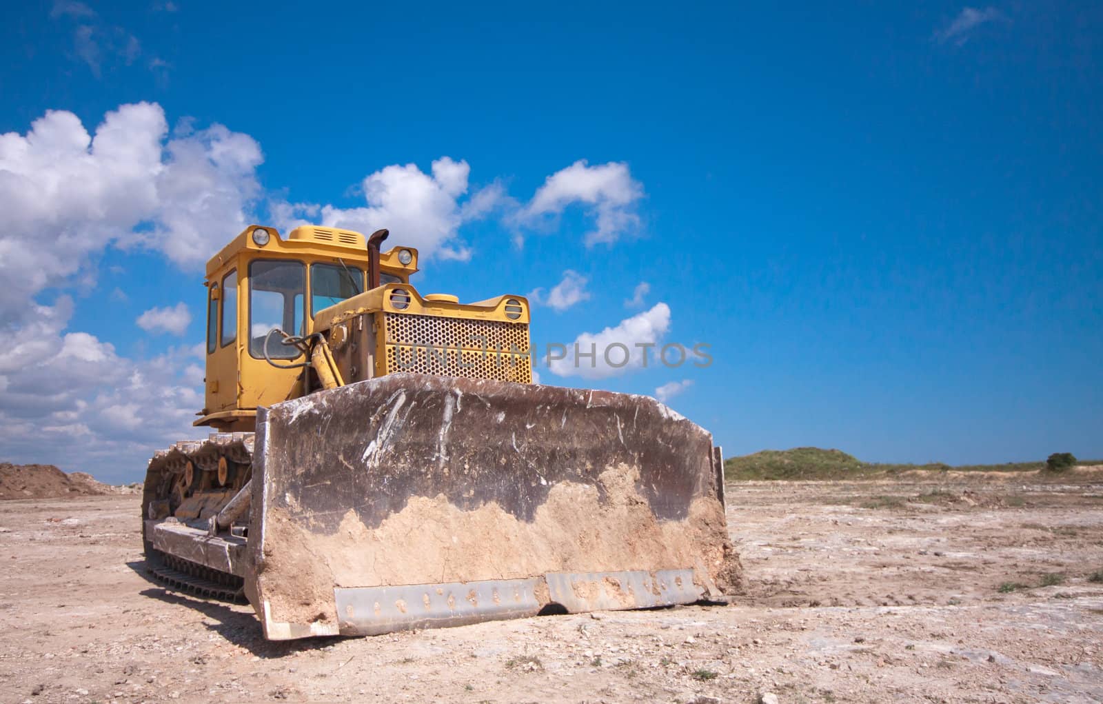 orange bulldozer after the work is on a background of blue sky