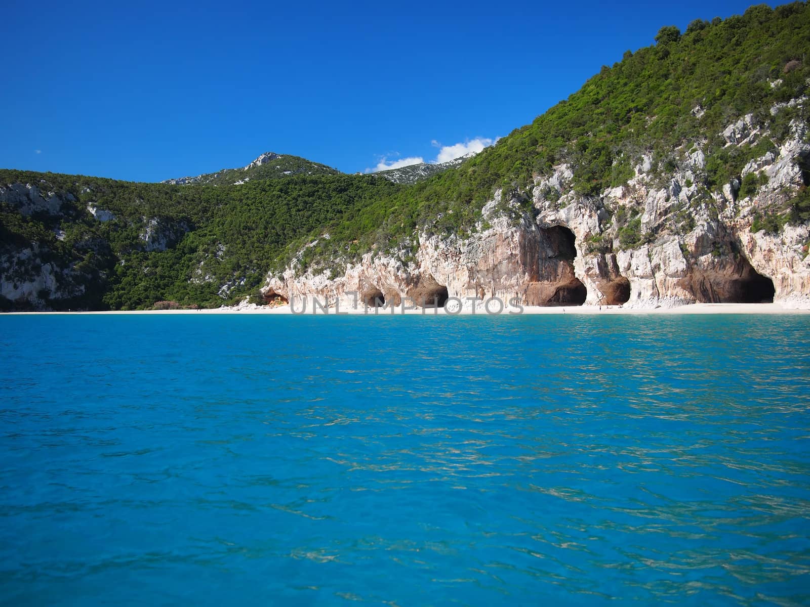 Blue sea and the characteristic caves of Cala Luna, a beach in the Golfo di Orosei, Sardinia, Italy.