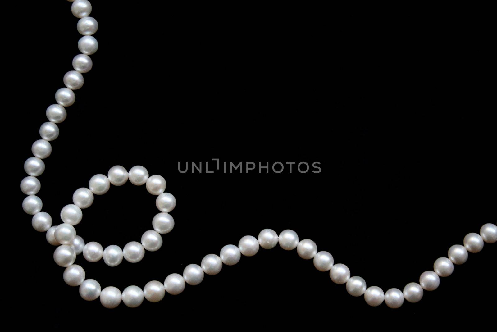 White pearls on the black velvet background 