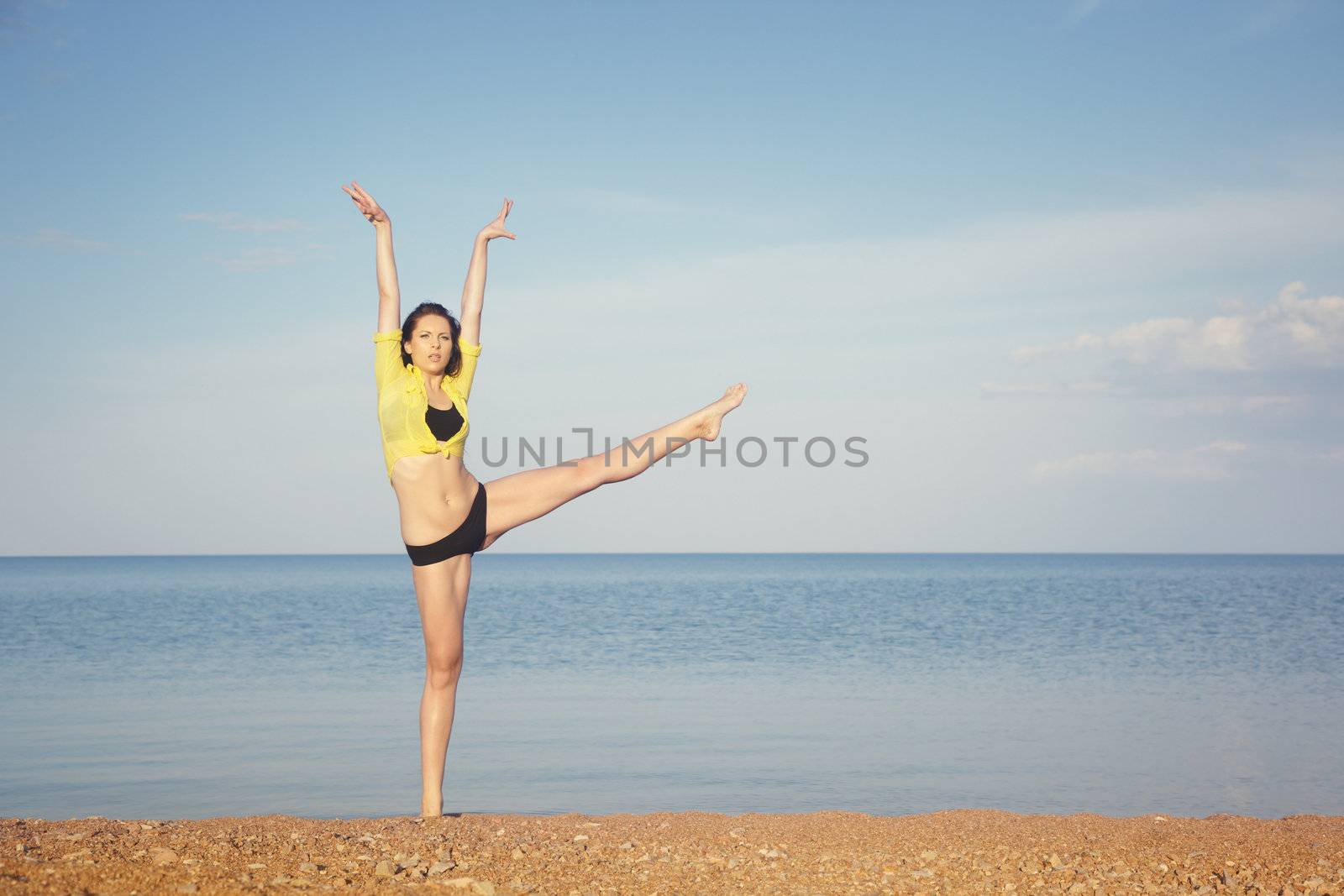 Brunette lady at the summer beach doing sportive exercise