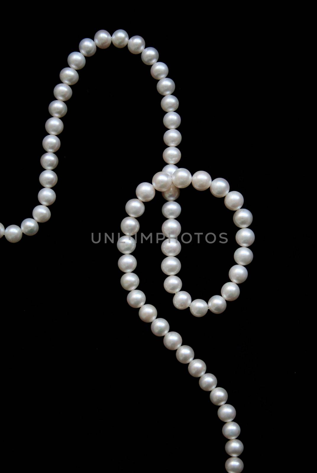 White pearls on the black velvet background 