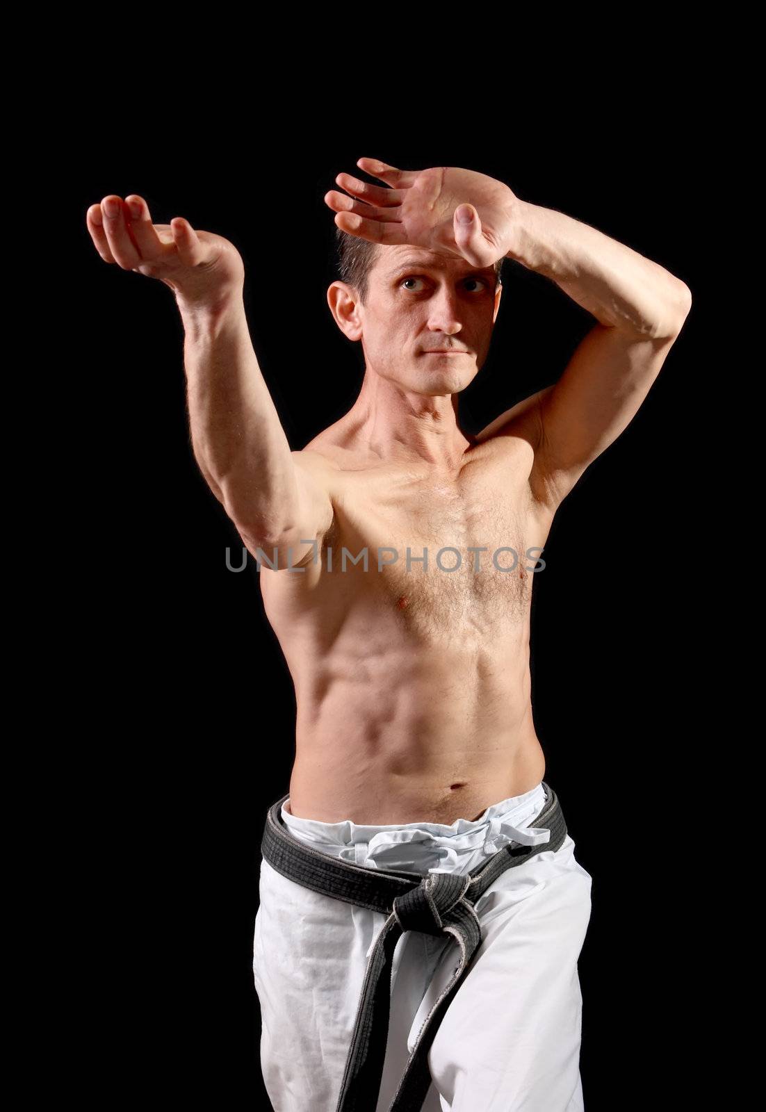 Karate. Man in a kimono with a black background