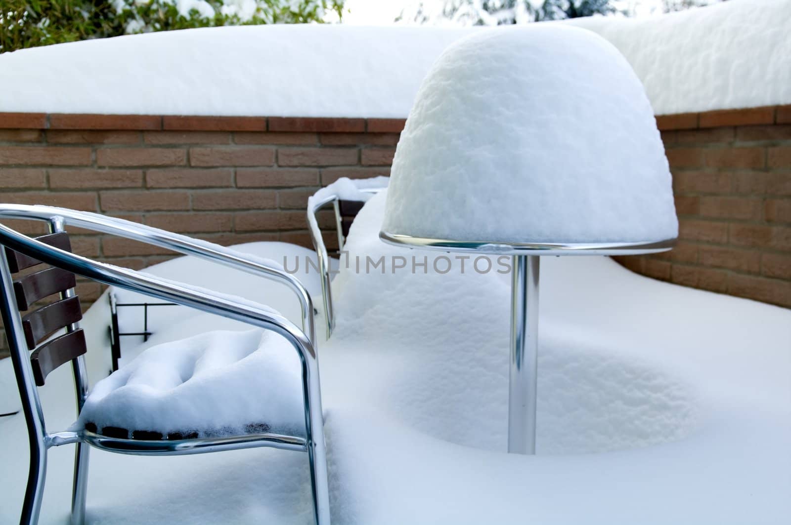 Table and chairs covered in snow a winter day at Castelvetro