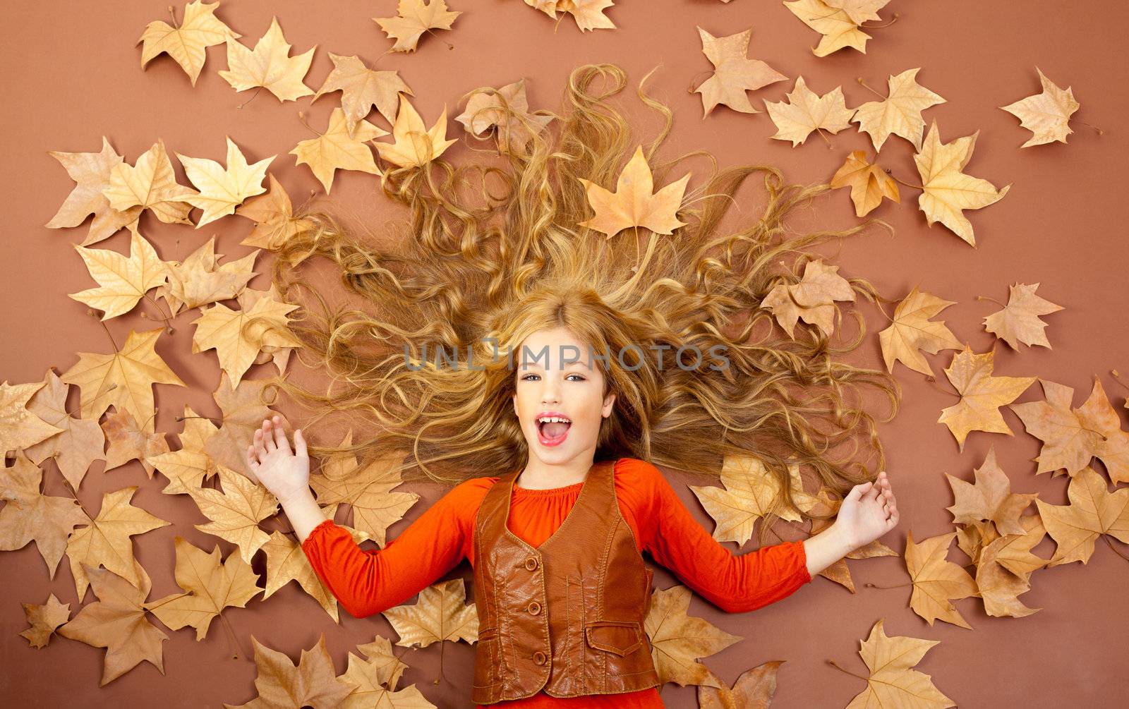 autumn fall little blond girl on dried tree leaves by lunamarina