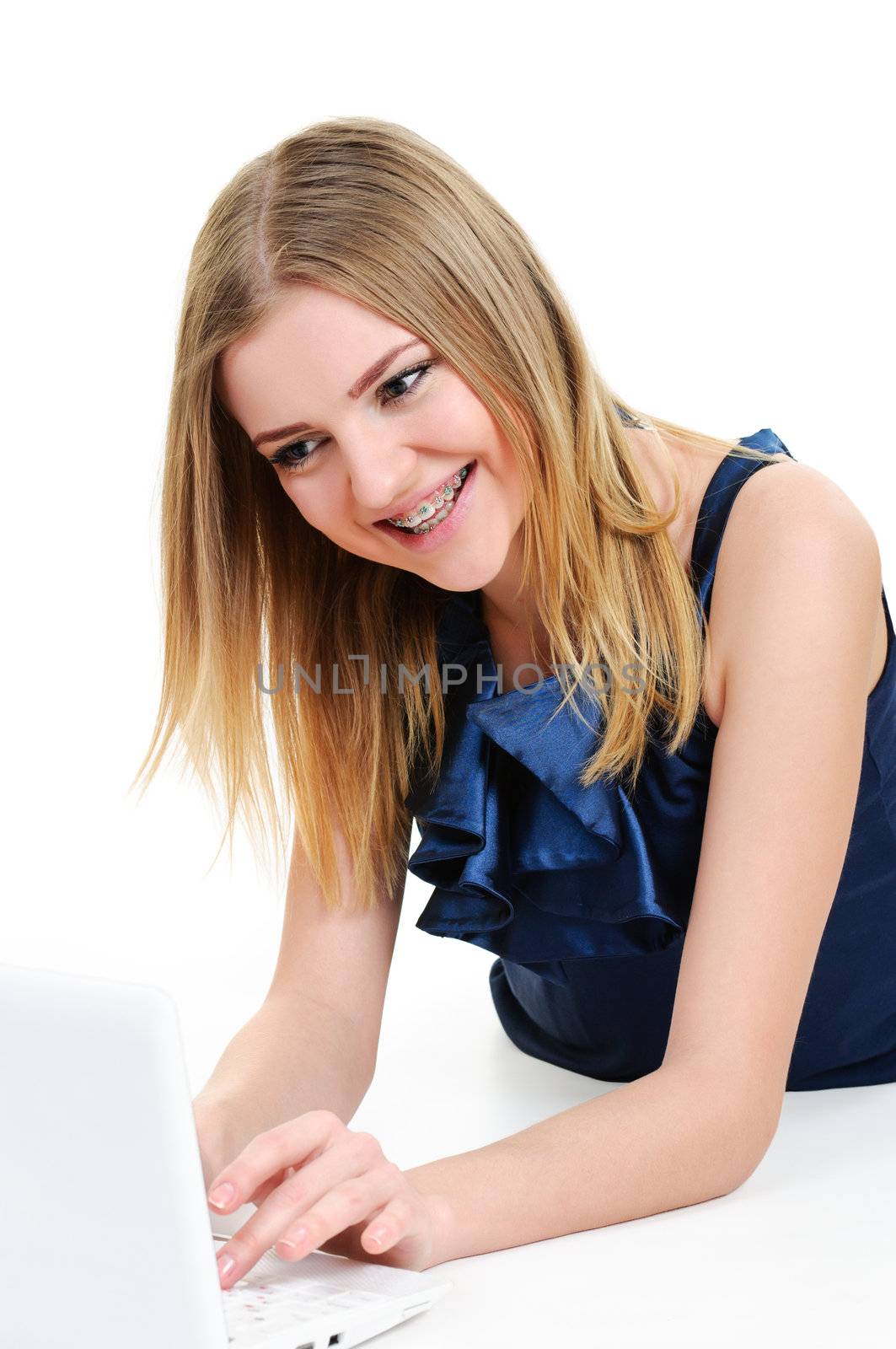 girl with braces working on laptop on white background 