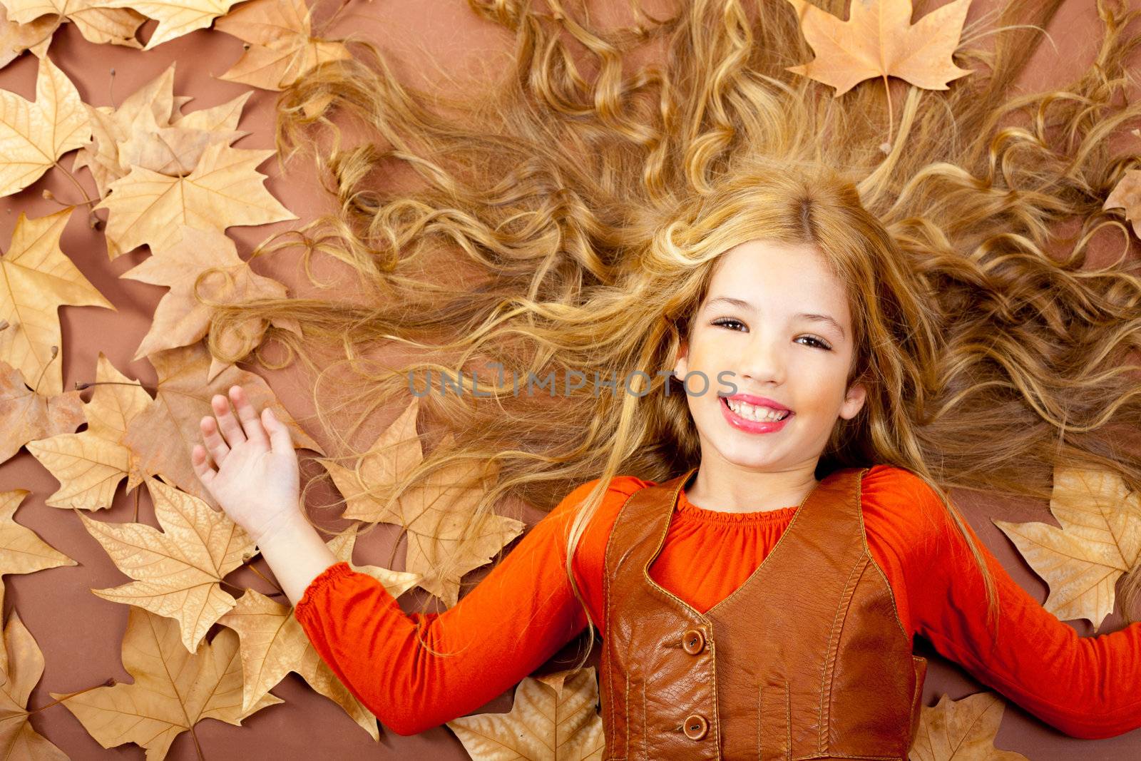 autumn fall little blond girl on dried tree leaves by lunamarina