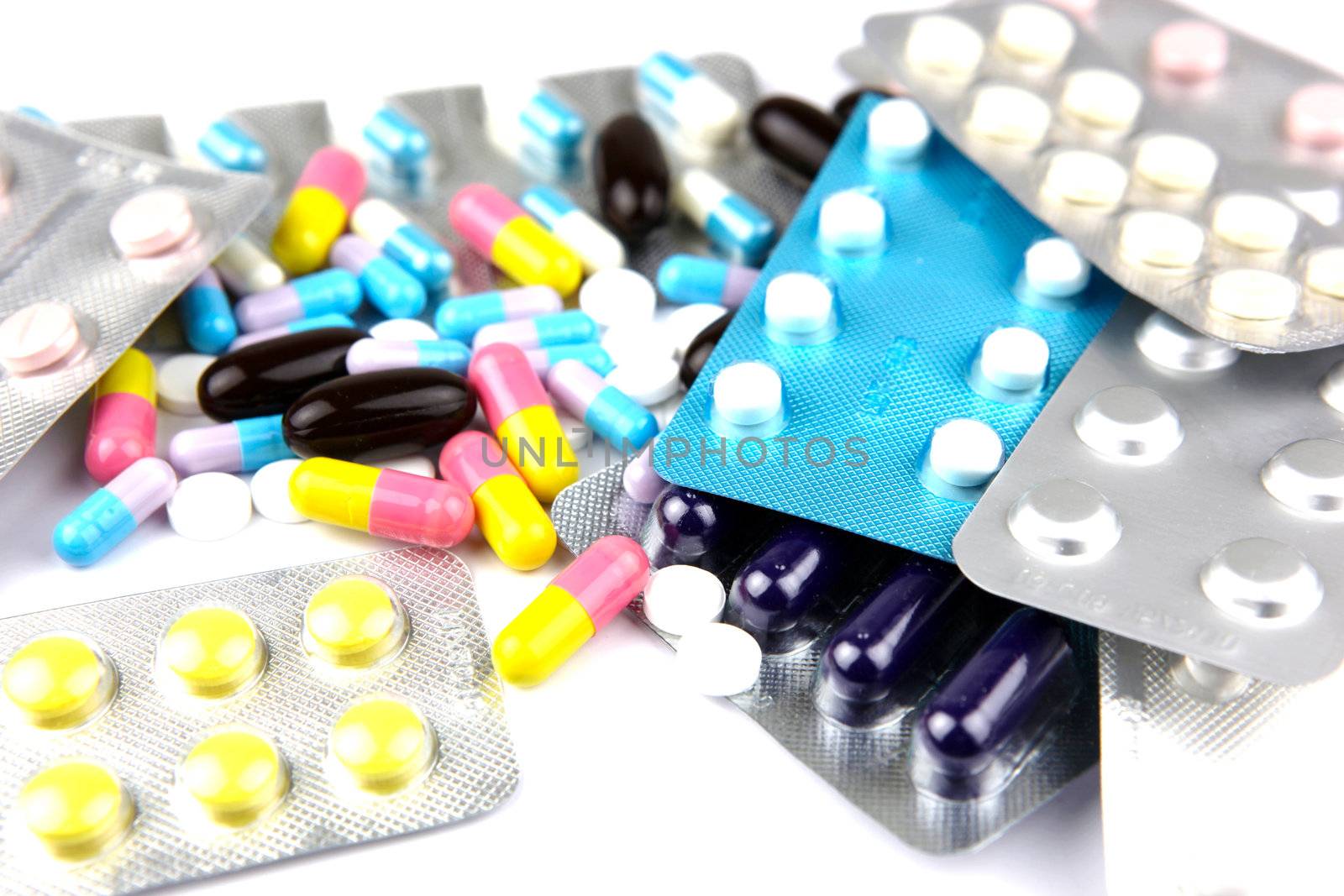 Pills of many shapes and colors grouped together.
