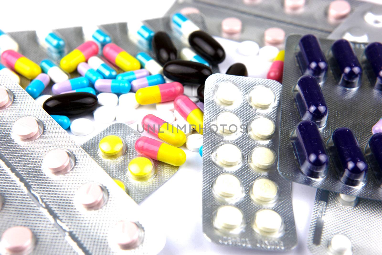 Pills of many shapes and colors grouped together.