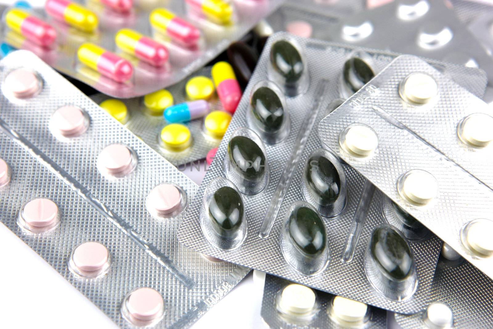 Pills of many shapes and colors grouped together.