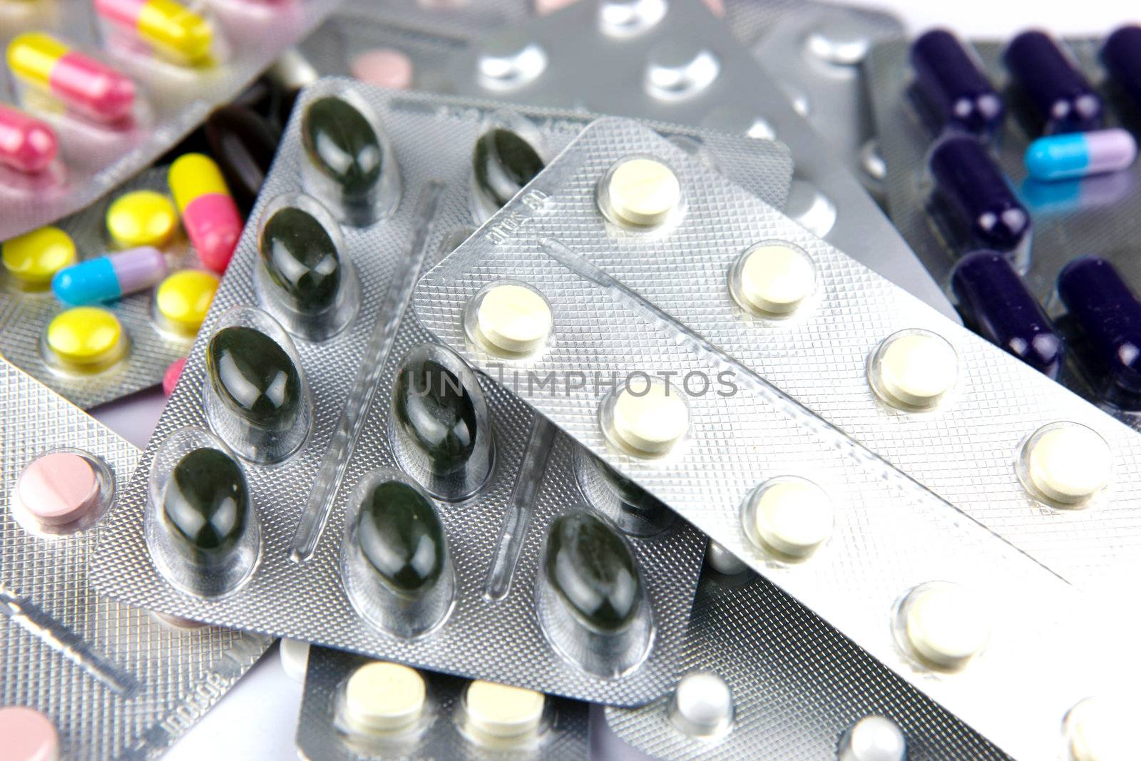 Pills of many shapes and colors grouped together.